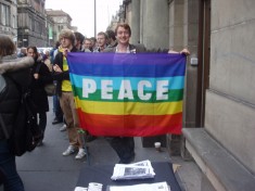 Person holding up rainbow peace flag
