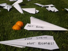 Paper aeroplanes on grass with "drop steve, not bombs!" written on them