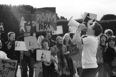 Disarm York student protest. Student in foreground with megaphone and students in background with placards